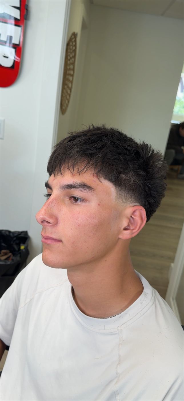 Textured crop with a mid-taper fade, side profile